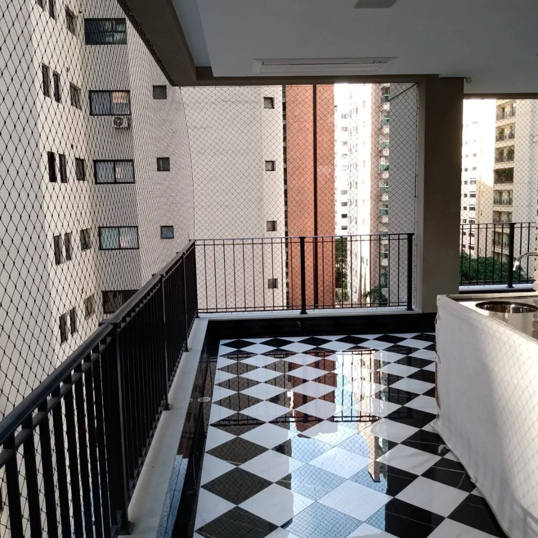 Sacada com rede de proteção e piso xadrez